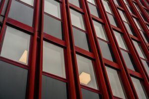 Close-up van moderne rode kozijnen en dubbel glas in een kantoorgebouw, illustratie van isolatie en energie-efficiëntie