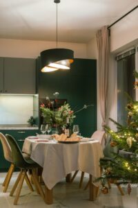 Gezellig gedekte eettafel met kerstdiner en kerstboom als inspiratie voor wat te doen met kerst thuis