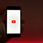 Telefoon met YouTube logo als voorbeeld van hoe je een YouTube kanaal maakt.