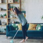 Vrouw met blote voeten op watergedragen vloerverwarming in een goed geïsoleerde woning als voorbeeld van duurzaam verwarmen.