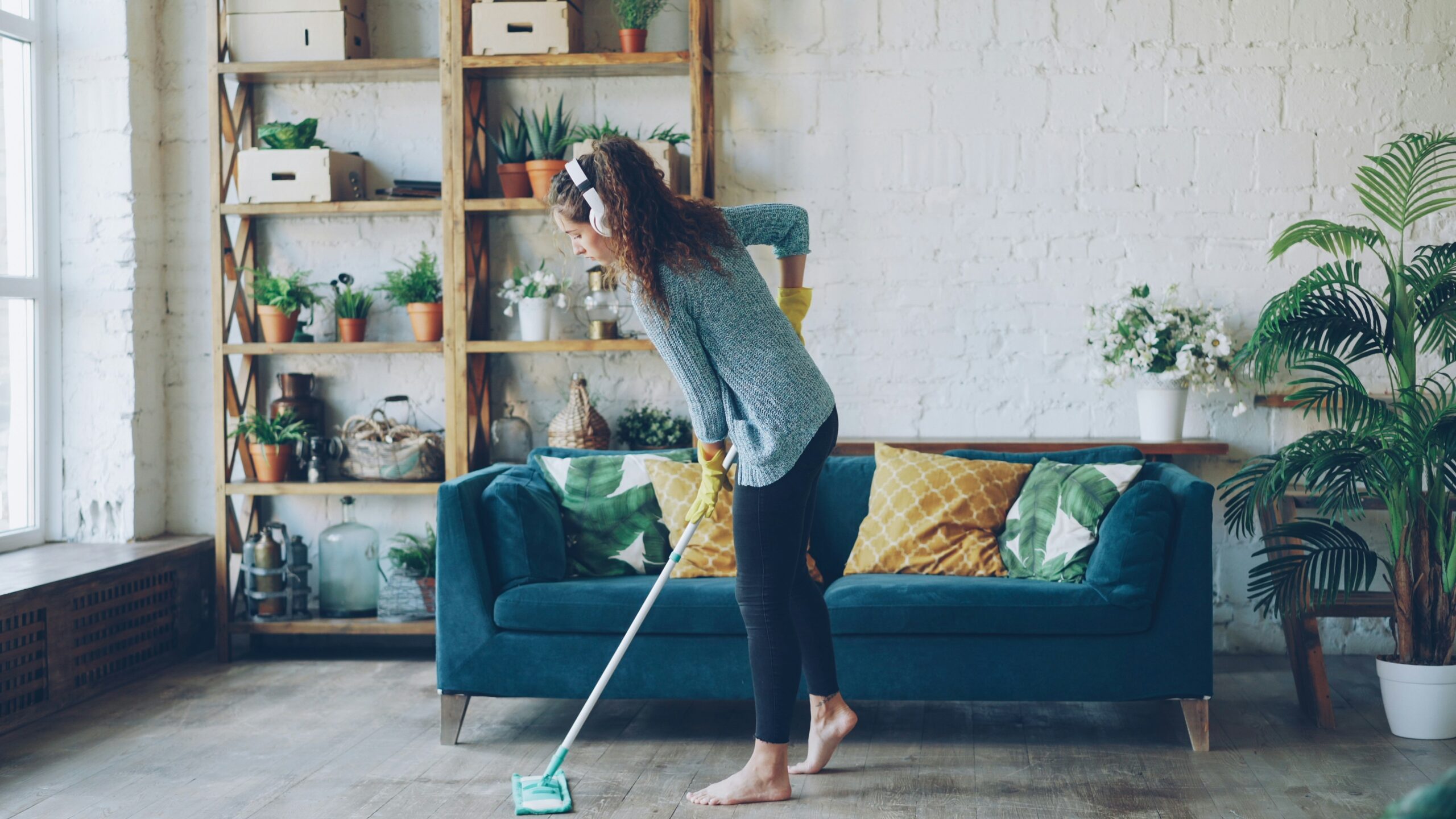 Vrouw met blote voeten op watergedragen vloerverwarming in een goed geïsoleerde woning als voorbeeld van duurzaam verwarmen.
