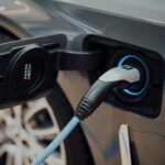 Elektrische auto aan een laadpunt bij een bedrijfspand.