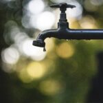 Waterkraan boven een spoelbak op een werkplek.