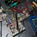 Technicus werkt met gereedschap aan een elektronisch apparaat.