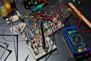 Technicus werkt met gereedschap aan een elektronisch apparaat.