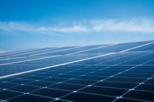 Blauwgekleurde zonnepanelen op een dak in het daglicht.